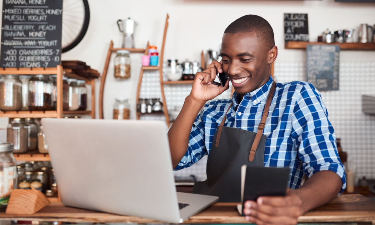 Young restaurant worker smiling at laptop